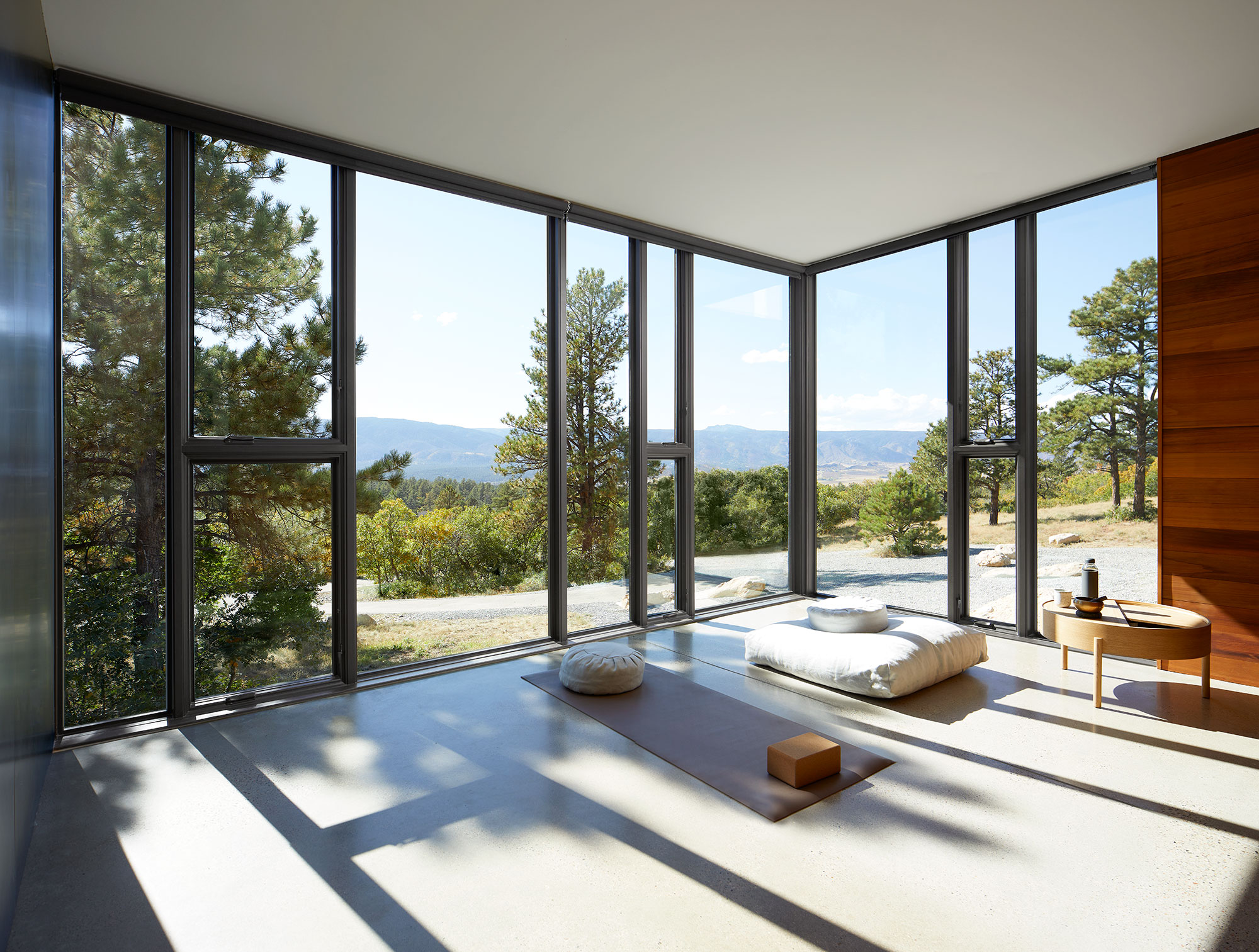 Corner picture windows in meditation room with mountain view