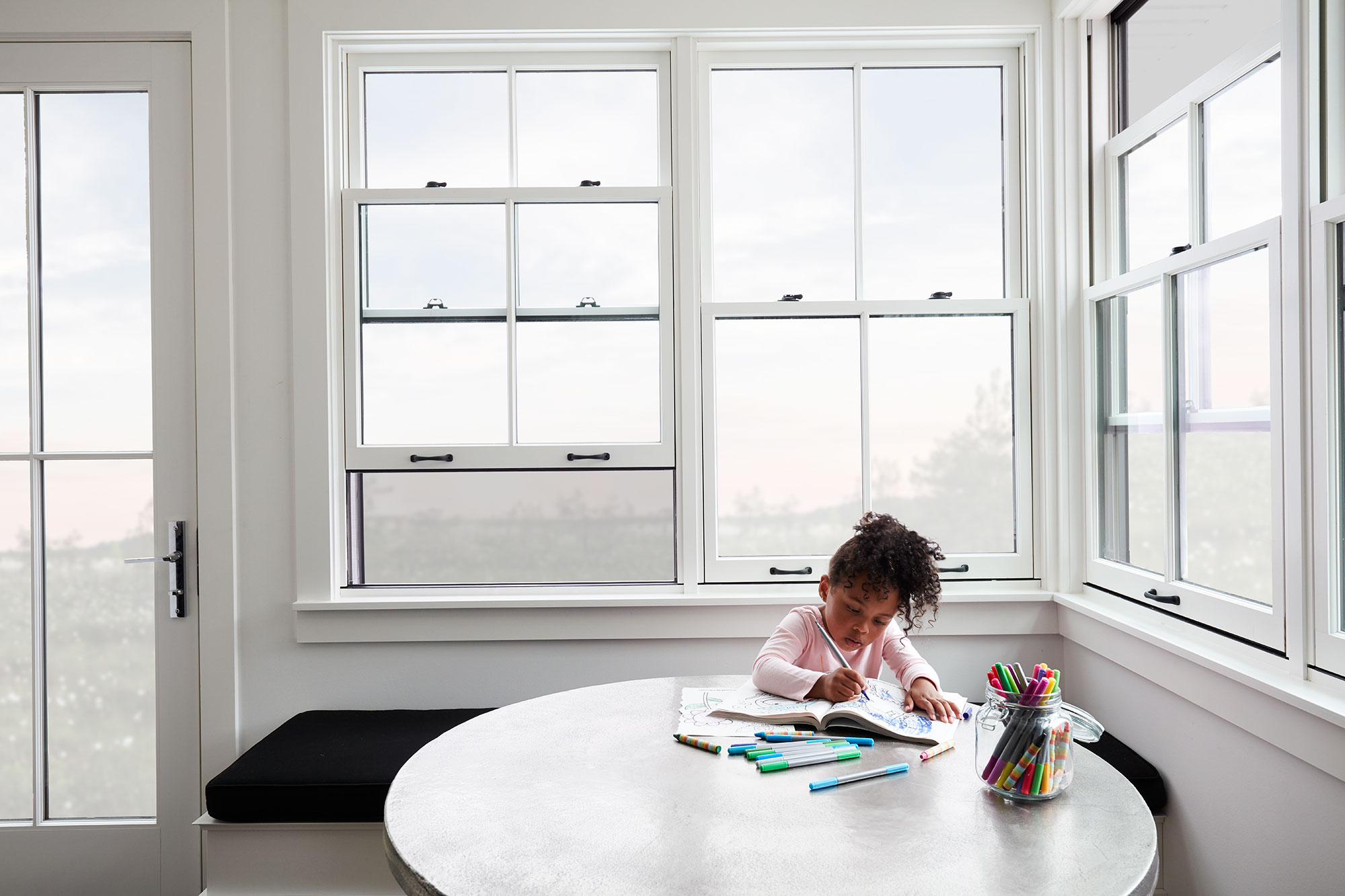 Child drawing by single-hung windows