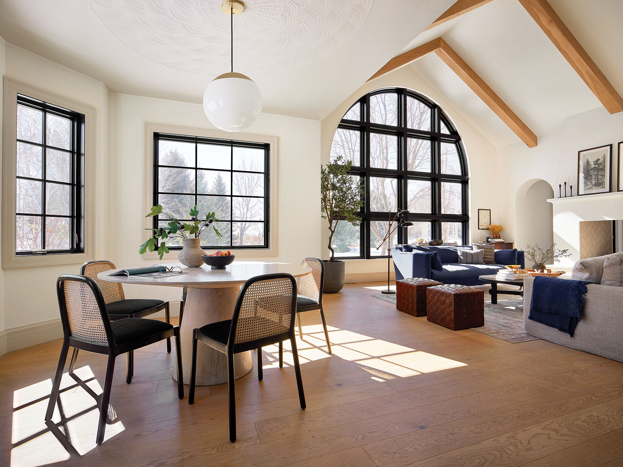 Black arched window in vaulted living room with exposed beams