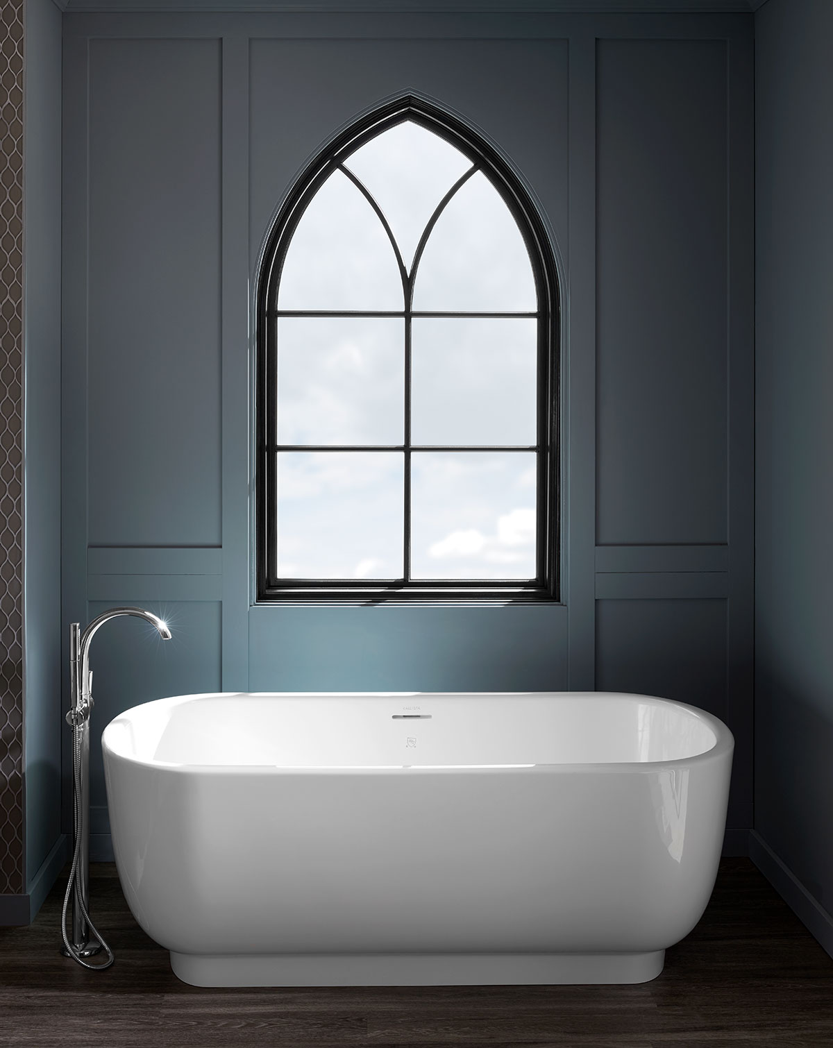 Gothic pointed arch window above freestanding bathtub